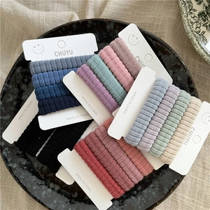 Détail d'élastiques à cheveux en tissu côtelé de couleurs variées sur carte blanche