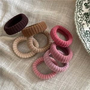 Lot de 7 chouchous en tissu côtelé aux tons Morandi sur fond en lin beige naturel