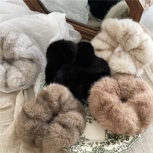Luxe plush faux mink fur scrunchies in neutral tones on a vintage decorative plate