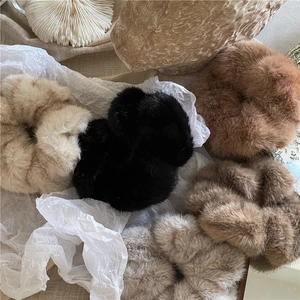 Faux mink fur oversized scrunchies in autumn earth tones on aesthetic natural background