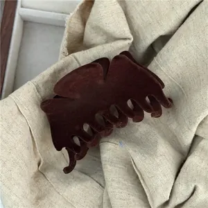 Close-up of deep brown velvet hair claw clip with plush texture for stylish hair styling