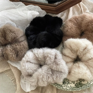 Detailed view of five plush faux mink hair scrunchies in neutral earth tones