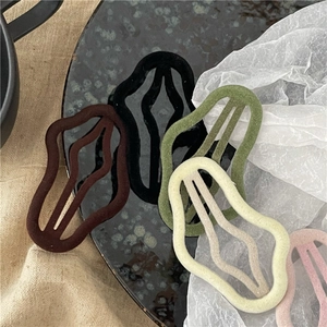 Five-piece velvet wave hair clip set in assorted autumn colors on textured background