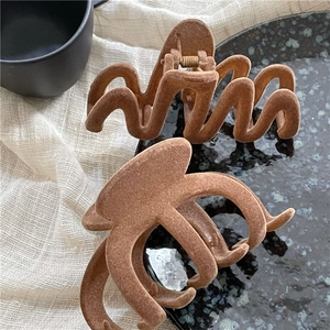 Brown flocked hair claw clips set with wavy and rectangular geometric designs in coffee hue
