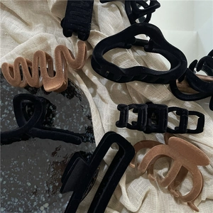 Detailed view of flocked geometric hair claws with black and brown wavy textures