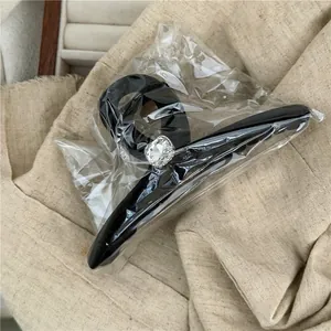 Detail of a large black hair claw clip featuring a square sparkling crystal gemstone