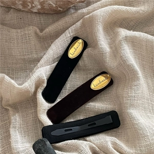 Rectangle velvet hair clips in black and dark brown with gold handmade metal labels