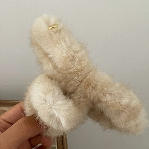Dettaglio molletta per capelli in peluche crema con ciondolo a cuore in lega dorata
