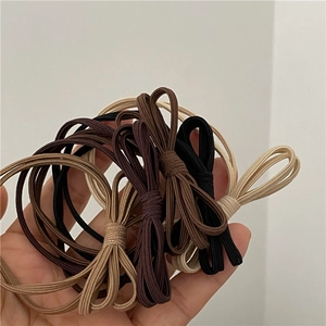 Détail de chouchous à nœuds multicouches tons café montrant la texture élastique