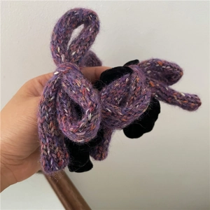 Detailed view of the handmade purple knit rabbit ear hair accessory with black velvet lining