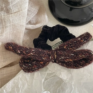 Detail of a handmade knit bow hair tie with black velvet scrunchie for women