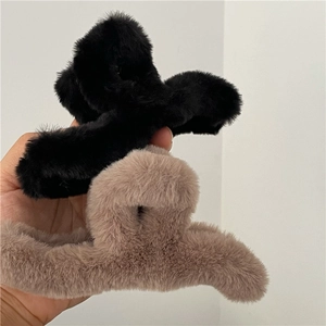 Detail shot of plush faux fur hair claw clips in black and beige colors