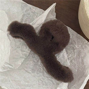 Detail of large brown plush hair claw clip with soft faux fur texture for winter styling