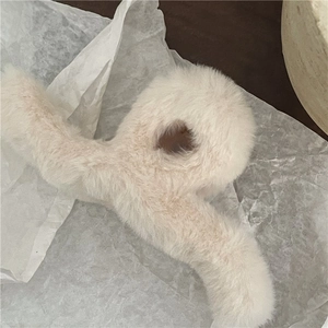 Close-up of soft faux fur hair claw clip in cream white with plush texture and teeth detail