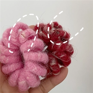 Gros plan de chouchous en laine tricotée rose et bordeaux avec une texture douce