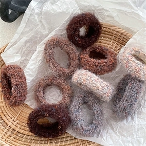 Close-up of thick plush knit hair ties in earthy tones like coffee brown and beige