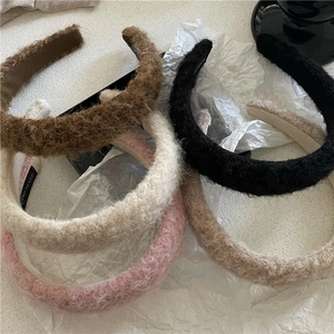 Detail shot of colorful plush headbands showing thick fuzzy texture and handmade labels