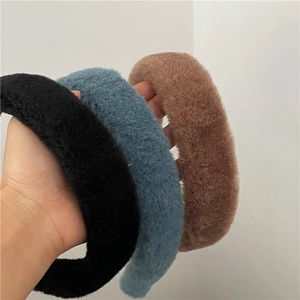 Gros plan de serre-têtes d'hiver en peluche douce, coloris noir, bleu et marron chiné