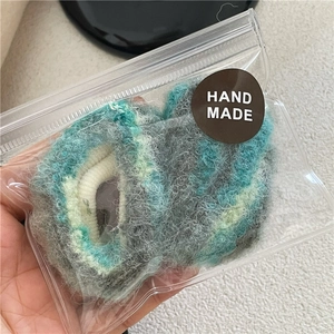 Dettaglio degli elastici per capelli pelosi stile pittura a olio in confezione fatta a mano