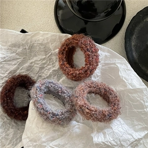 Close-up of plush knit hair ties in coffee tones with soft fuzzy texture for winter