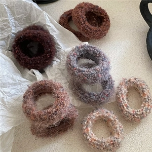 Plush mixed color hair ties in coffee and cream tones on a textured white background