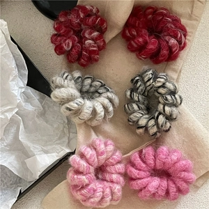 Vue détaillée d'élastiques à cheveux spirales en laine en rouge, noir et rose tendre