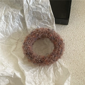 Close-up of coffee brown plush hair tie showing fuzzy wool blend and colorful fibers