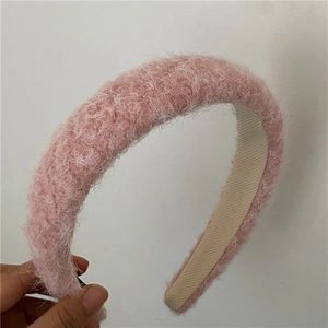 Detail of pink plush headband showing soft faux fur texture and anti-slip inner lining