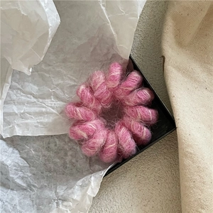 Détail de l'élastique spirale en peluche rose et blanche avec texture douce en fausse fourrure