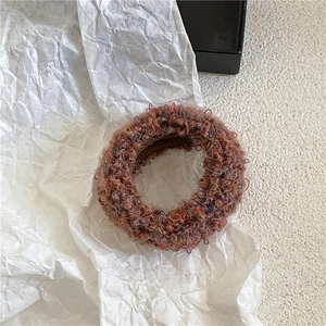 Close-up of soft plush knit hair tie with colorful wool blend yarn and elastic texture