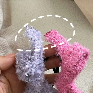 Gros plan détaillé de chouchous en laine d'agneau pelucheuse en violet pastel et rose vif