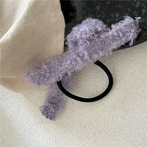 Vue détaillée d'un chouchou en peluche lavande avec texture polaire et élastique noir