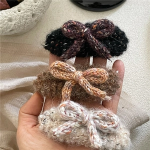 Lot de trois barrettes à cheveux en laine tricotée en noir, marron et blanc crème