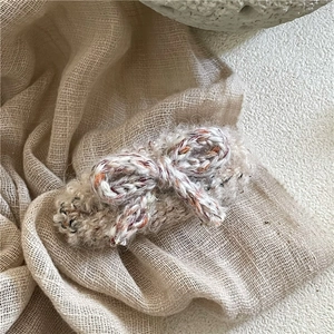 Gros plan sur une pince à cheveux en forme de nœud au crochet fait main, maille douce