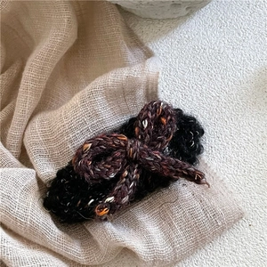 Vue macro d'une barrette à cheveux nœud tricoté main avec des textures de laine