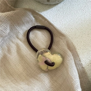 Détail du pendentif cœur en résine avec pétales de fleurs séchées sur l'élastique