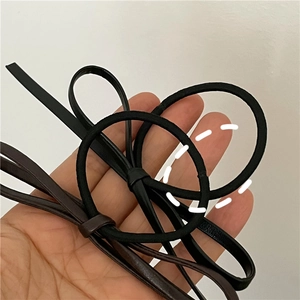 Detailed view of handmade PU leather bow hair ties in black and dark brown colors