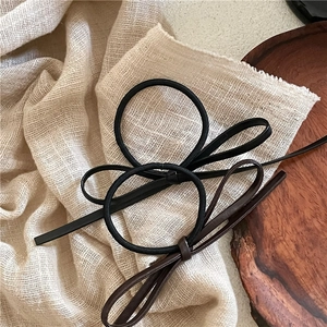 Detail showing high-elastic hair ties with minimalist black and brown PU leather bows
