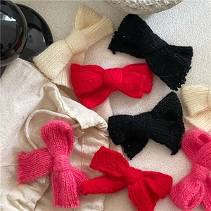 Gestrickte Schleifen-Haarspangen in verschiedenen Farben auf minimalistischem Hintergrund