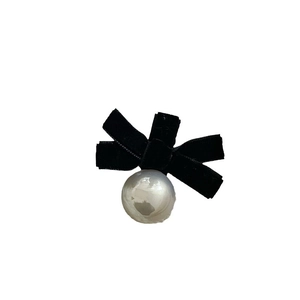 Elegant black velvet bow hair clip with a large glossy white pearl on a white background