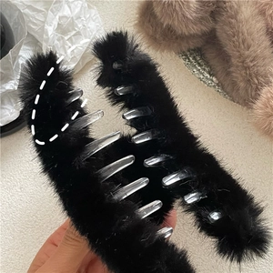 Detail of large black faux mink fur hair claw clip showing fluffy texture and grip size