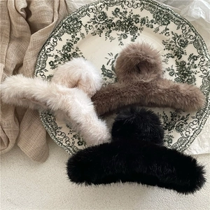 Faux mink fur hair claw clips in cream, coffee and black displayed on vintage ceramic plate