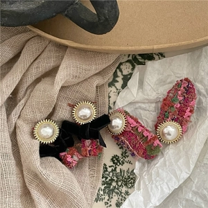 Set of retro velvet and tweed bow hair clips with faux pearl accents and gold details