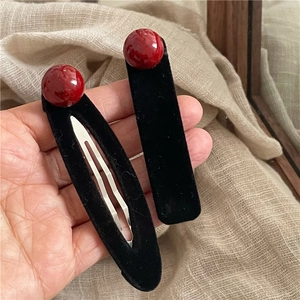 Set di fermagli per capelli in velluto nero con sfere rosse su fondo di lino