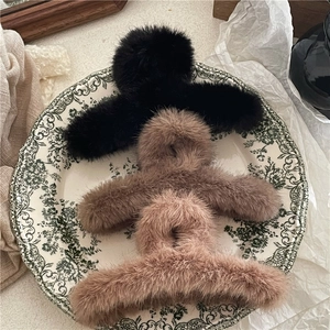 Detailed view of three faux mink fur large hair claw clips in black, brown and beige colors