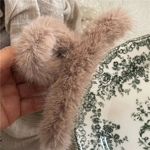 Detail shot of a large milk-tea colored plush hair claw clip with fluffy faux mink fur