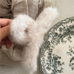 Detail shot of fluffy cream faux fur hair claw clip with soft texture and internal spring