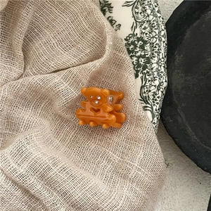 Détail d'une mini pince à cheveux ours orange avec strass et découpe en forme de cœur