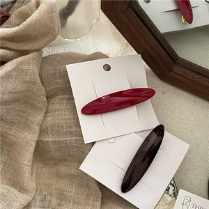 Detail showing red and brown acetate barrettes with Barrette La France gold lettering