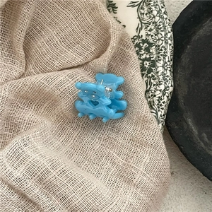 Détail d'une pince à cheveux petit ours bleu avec découpe cœur sur assiette rétro